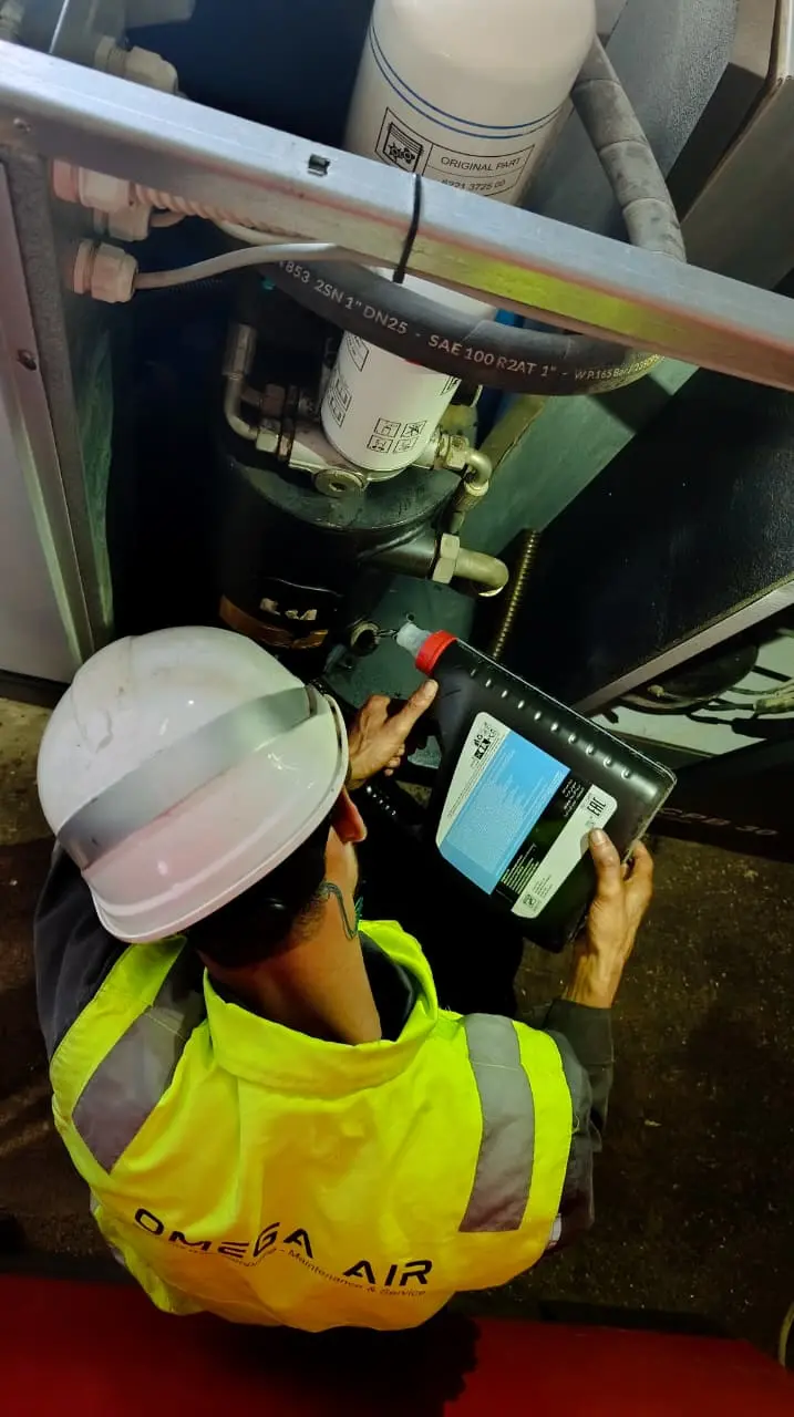 Technicien OMEGA AIR réalisant une maintenance sur un compresseur industriel